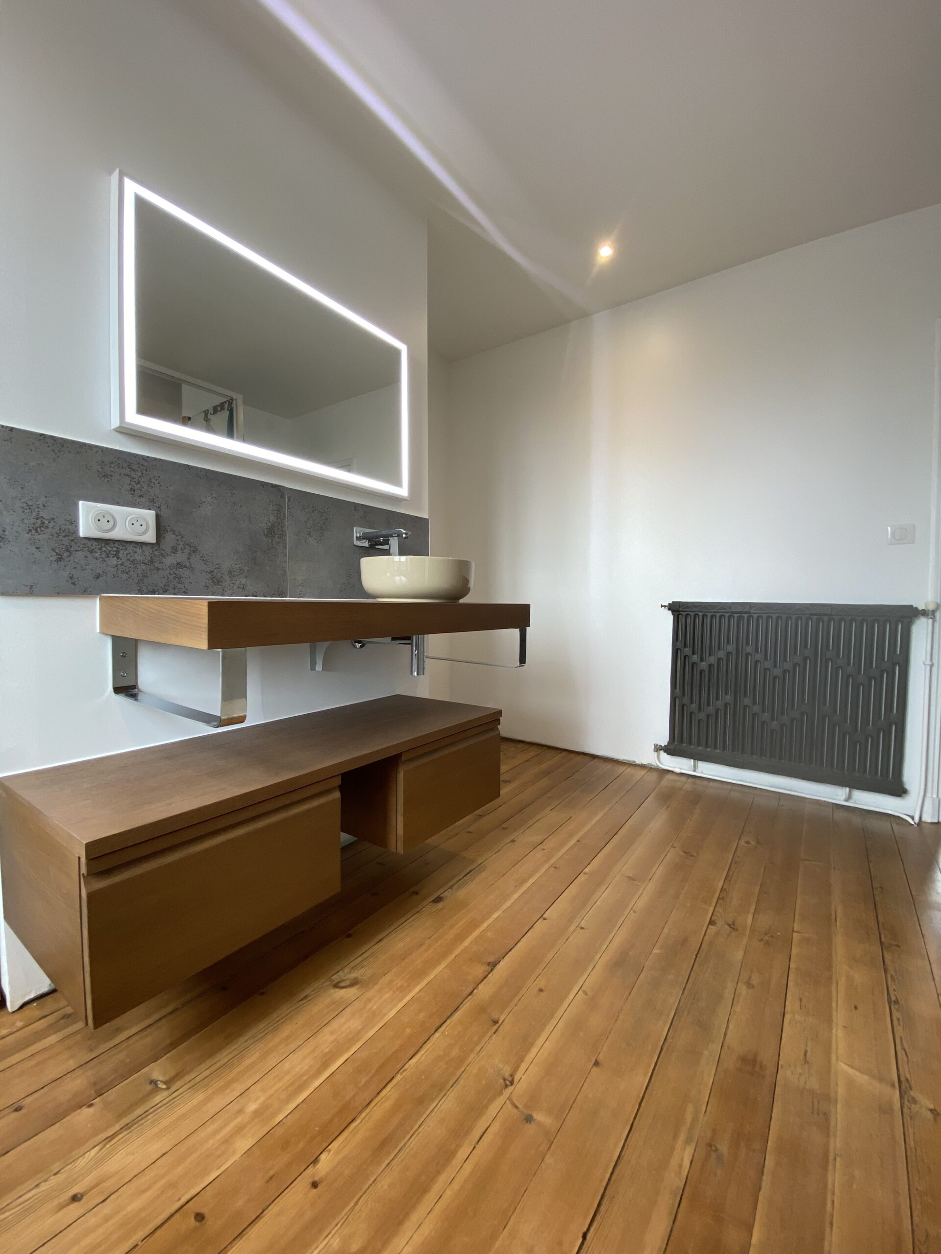 Salle de bain, évier suspendu et miroir leds, chauffage en fonte.